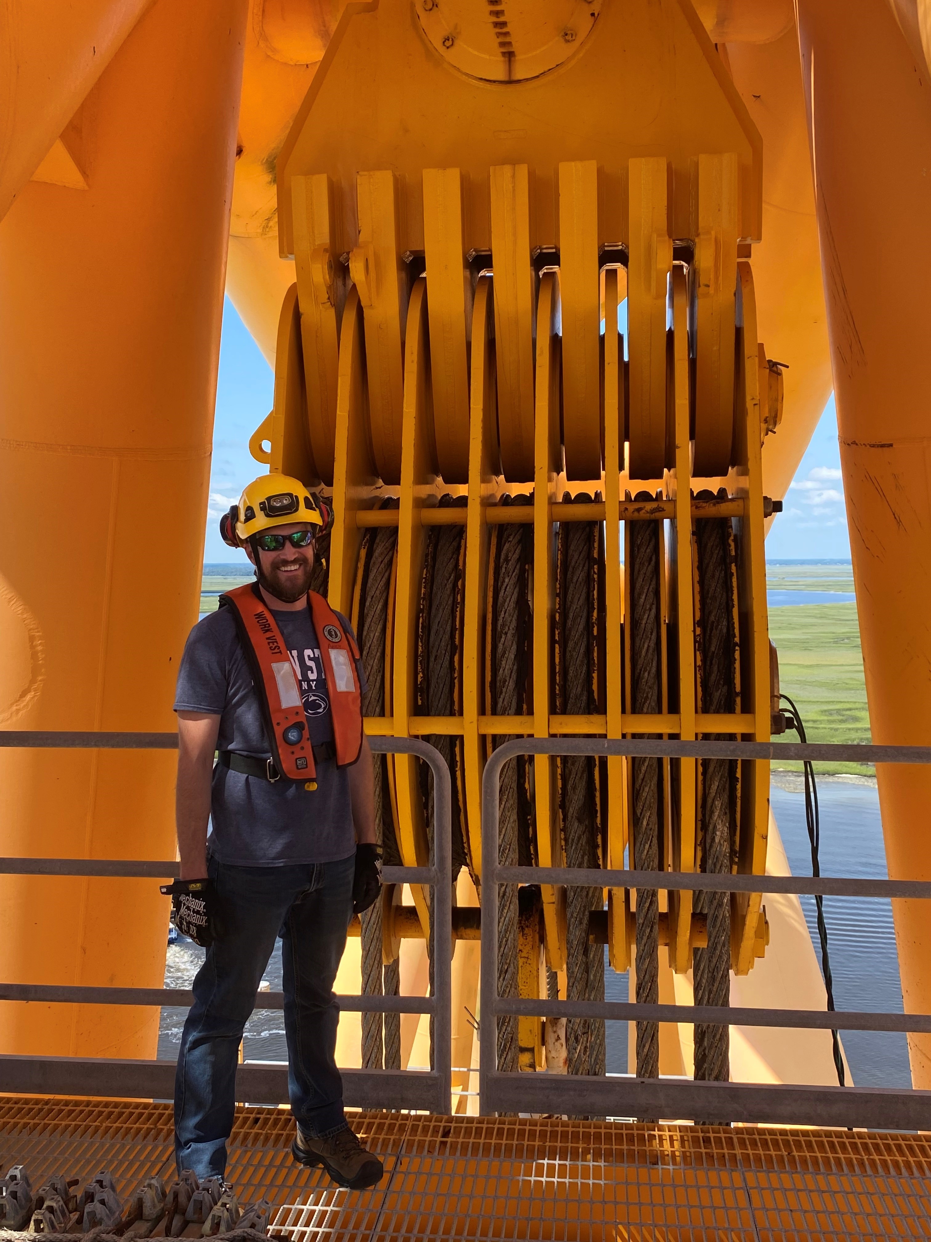 Member of SERT posing in front of a crane at a salvage case.